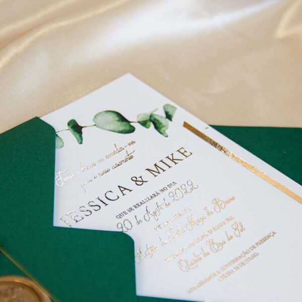 O convite casamento verde e dourado Bellevue contém envelope verde, lacre dourado e cartão branco com brilho dourado e ramos verdes de eucalipto